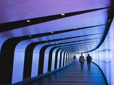 Two people walking through futuristic corridor